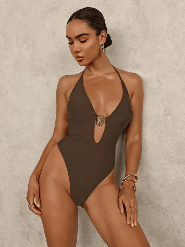 Woman wearing a brown swimsuit against a neutral background