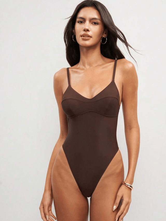Woman wearing a brown swimsuit against a white background