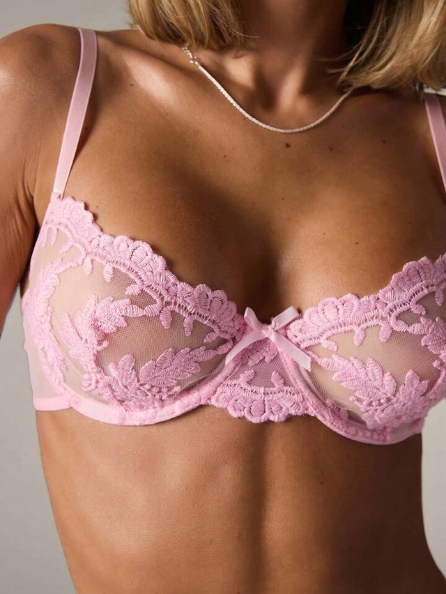 Pink lace bra on a neutral background