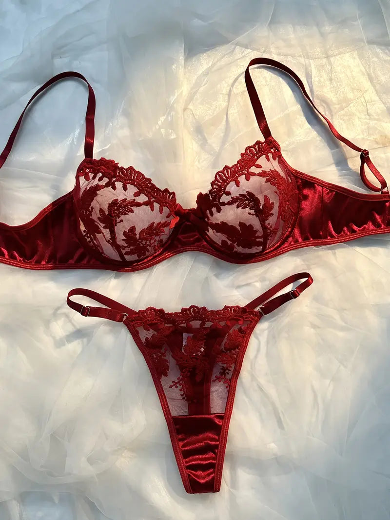burgundy lingerie bra set with sheer floral cups, scalloped trim, adjustable straps and matching thong laid flat