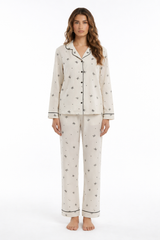 Ivory bow print pyjama set with button-through long sleeve shirt, contrast piping and matching trousers.