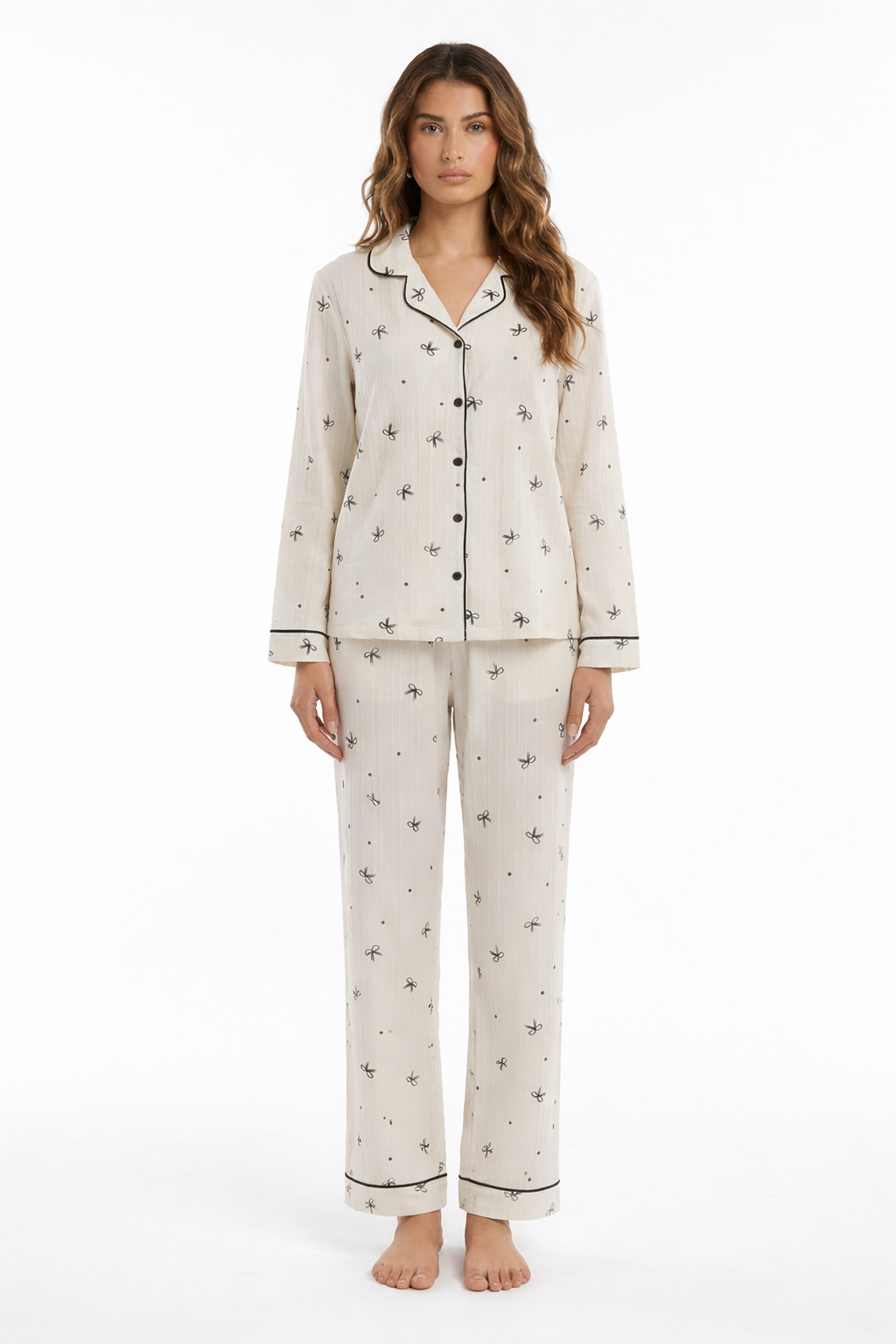 Ivory bow print pyjama set with button-through long sleeve shirt, contrast piping and matching trousers.